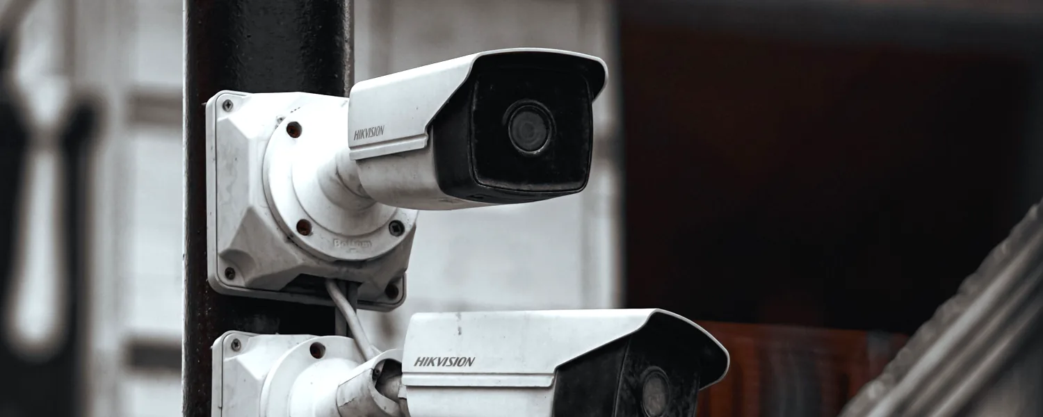 Ba camera giám sát gắn trên cột, hướng ra lối vào khu nhà.