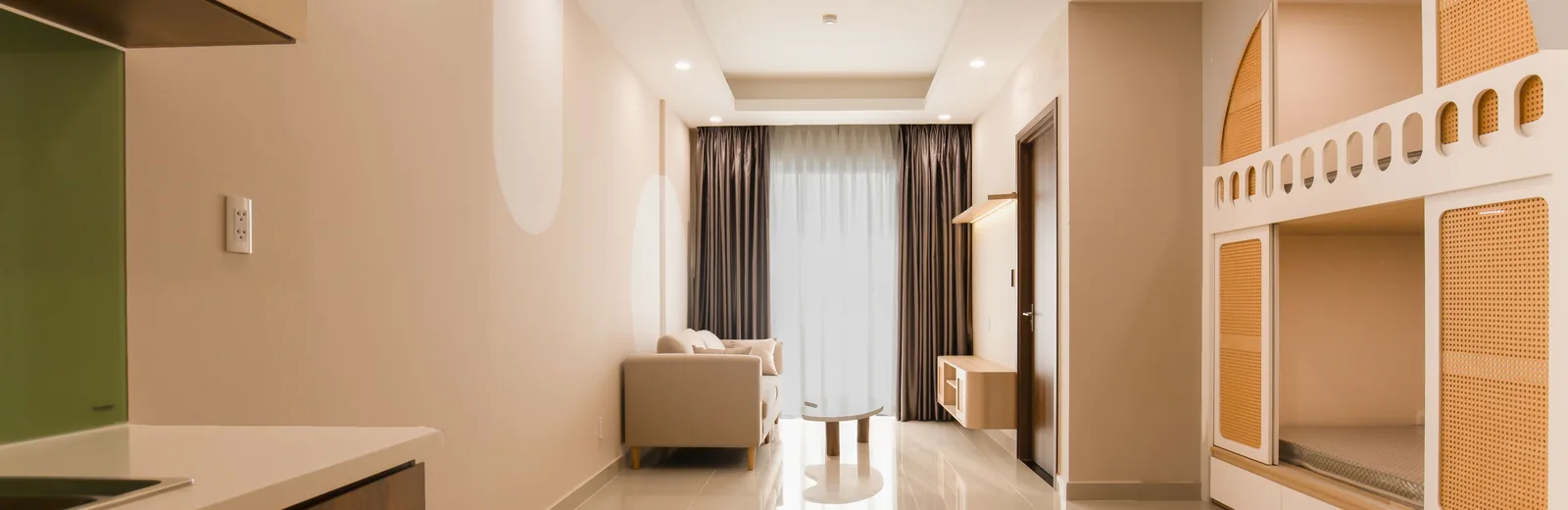 Một phòng trống vừa hoàn thiện, tủ âm tường và kệ gỗ đón nắng buổi sáng.