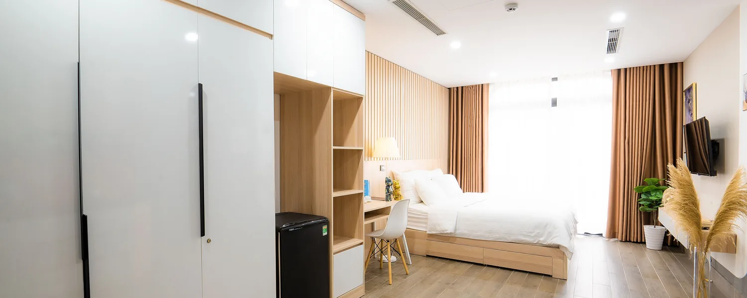 Phòng cho thuê đã hoàn thiện: tủ áo âm tường, giường, bàn làm việc và rèm cửa.